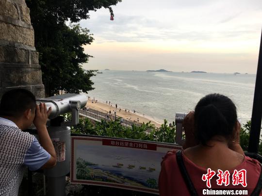 游客在瞭望臺(tái)用望遠(yuǎn)鏡眺望一水之隔的金門列島景色。楊伏山 攝