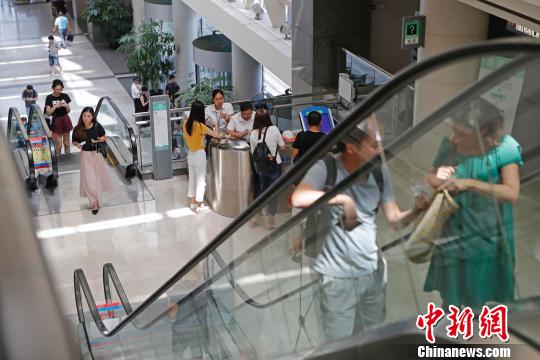 上海市公安局出入境管理局內(nèi)，民眾正在咨詢和辦理相關(guān)業(yè)務(wù)?！∫罅⑶?攝