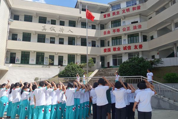 圖2：開(kāi)學(xué)第一天，巖山中學(xué)學(xué)生與巖山小學(xué)學(xué)生一起升國(guó)旗。