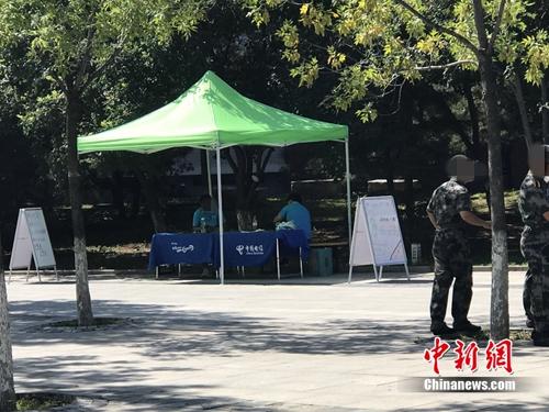 中國(guó)電信在某高校內(nèi)擺攤出售手機(jī)卡，旁邊就是正在軍訓(xùn)的學(xué)生。<a target='_blank' href='http://www.chinanews.com/' >中新網(wǎng)</a> 吳濤 攝