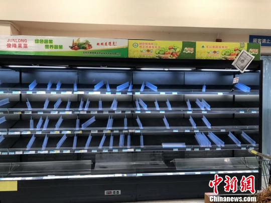圖為16日，南寧一家沃爾瑪超市內(nèi)被購空的果蔬菜架?！＄娦?攝