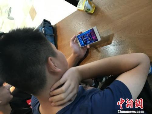資料圖：學(xué)生在玩熱門手機游戲?！√K飛宇 攝