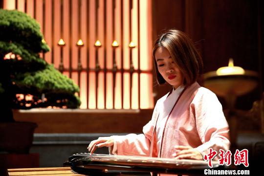 圖為志愿者在開幕式會(huì)場(chǎng)展示琴藝?！×籂?攝
