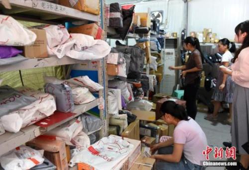某高校快遞點工作人員正忙碌著整理快遞，向?qū)W生撥打電話讓其盡快領(lǐng)取包裹。 周毅 攝