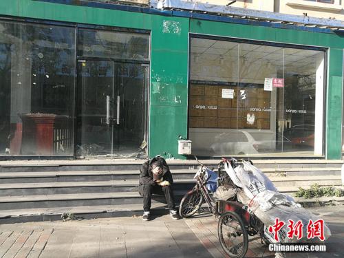 2018年10月，燕郊“售樓一條街”，已經(jīng)關(guān)門的鏈家門店前停著一輛裝貨的三輪車，車的主人坐在地上，把頭深深地埋進(jìn)臂彎。<a target='_blank' href='http://www.chinanews.com/' >中新網(wǎng)</a>記者 邱宇 攝