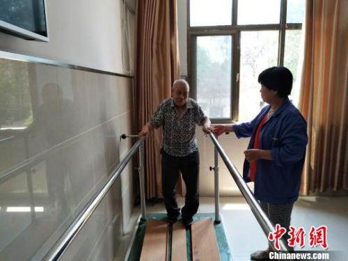 資料圖：老人在護(hù)工的協(xié)助下進(jìn)行康復(fù)訓(xùn)練。陳建華、薛艷偉供圖