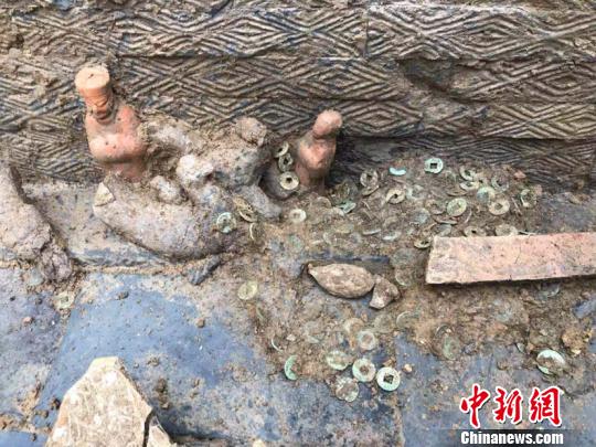 圖為墓葬出土的陶俑和銅錢。(鐘欣攝)