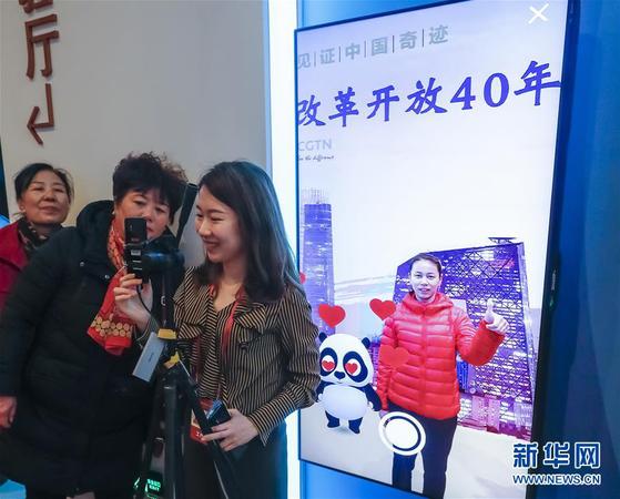 11月20日，在 “偉大的變革——慶祝改革開放40周年大型展覽”的壯美篇章展區(qū)，觀眾在體驗中央廣播電視總臺的AR體驗項目，與一只“CGTN熊貓”互動，并拍攝照片。