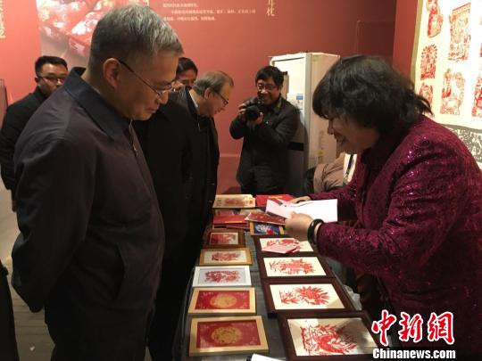 文化和旅游部黨組成員、副部長項(xiàng)兆倫參觀豐寧滿族剪紙展位?！「呒t超 攝