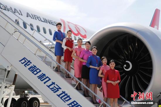 9月28日，上航波音787“夢(mèng)想飛機(jī)”首航成都。圖為身穿各個(gè)時(shí)代制服的乘務(wù)員在飛機(jī)邊合影留念。 殷立勤 攝