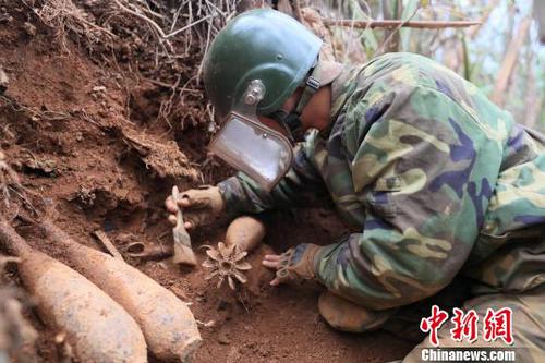 中國(guó)人民解放軍南部戰(zhàn)區(qū)陸軍云南掃雷大隊(duì)在雷場(chǎng)排除炮彈?！↑S巧 攝