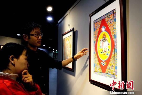 圖為設(shè)計(jì)師介紹彩繪寓意。　張?zhí)砀?攝