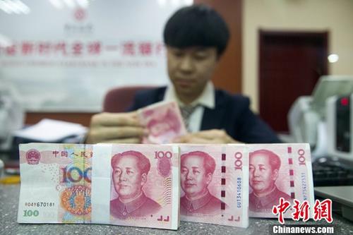 資料圖為11月1日，山西太原一銀行工作人員正在清點(diǎn)貨幣。中新社記者 張?jiān)?攝