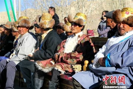 西藏阿里地區(qū)獨(dú)特的自然風(fēng)光及具有深厚文化底蘊(yùn)和舉世聞名的人文景觀，吸引著越來越多的游客走進(jìn)阿里，旅游業(yè)也讓當(dāng)?shù)孛癖姷玫皆絹碓蕉嗟膶?shí)惠。資料圖：阿里地區(qū)札達(dá)縣民眾在扶貧搬遷儀式上。札達(dá)縣委宣傳部供