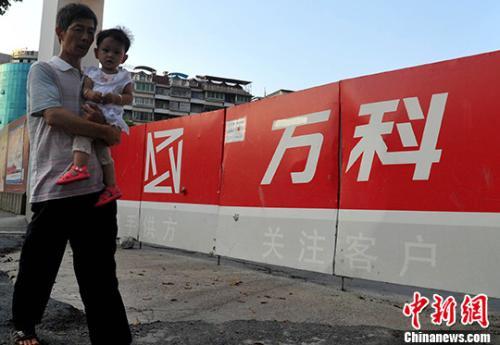 資料圖：民眾從萬科某樓盤工地旁經(jīng)過。<a target='_blank' href='http://www.chinanews.com/'>中新社</a>記者 張斌 攝
