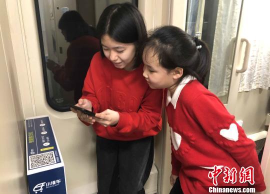 在南昌至北京西的Z66次列車10號車廂自動售貨柜前，徐伊然(右一)與姐姐秦玥茗正在通過掃描二維碼選購零食?！『鷩?攝