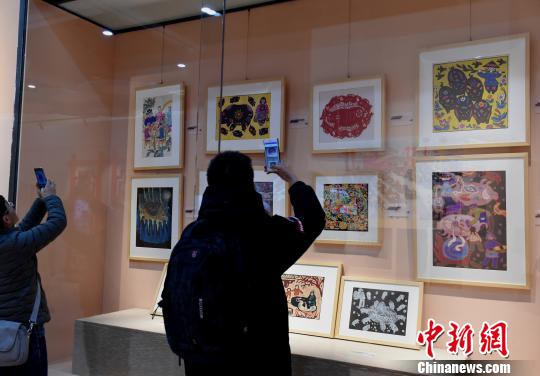 圖為《金豬賀歲》展覽，觀眾觀看“豬文化”藝術(shù)品?！≈芤?攝