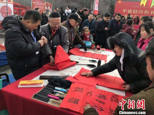 在古城南門(mén)內(nèi)的興國(guó)寺舊址，百名書(shū)法家揮筆潑墨，向民眾贈(zèng)送春聯(lián)?！『?攝