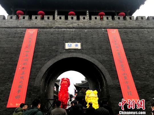 圖為城門掛春聯(lián)，揚(yáng)州開門紅?！〈藜衙?攝