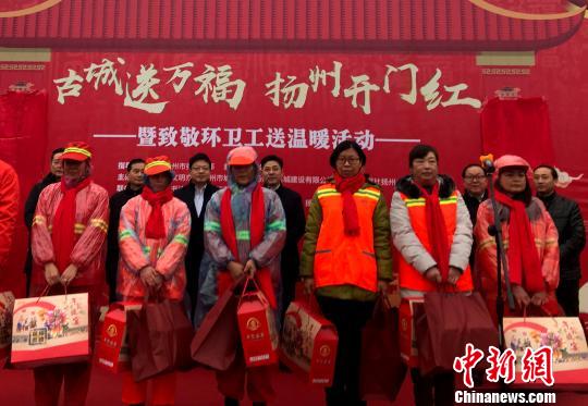 圖為現(xiàn)場向獲得“金掃帚”獎的環(huán)衛(wèi)工代表贈送春節(jié)禮包?！〈藜衙?攝