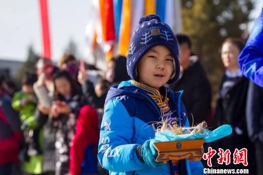 圖為小孩拿著貢品準(zhǔn)備祭火?！『?攝