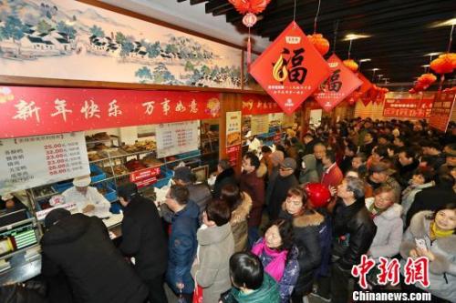 資料圖：民眾排長(zhǎng)隊(duì)購(gòu)熟食備年貨?；卢| 攝