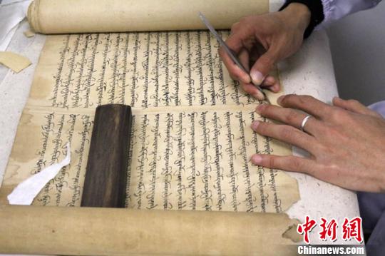 圖為文物保護專家正在對唐代藏文寫經(jīng)進行修復。　趙紅云 攝