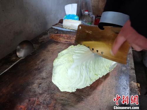 當(dāng)天中午，劉奉智熟練地切白菜、刷鍋、燒油，燉白菜湯，準(zhǔn)備午飯。　郝學(xué)娟 攝
