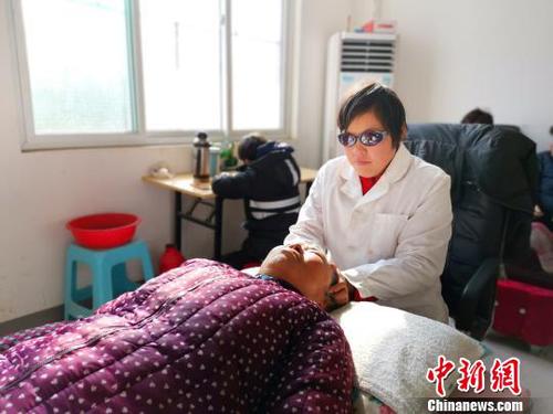 在社區(qū)服務(wù)中心，劉奉智母親為村里人按摩，劉奉智在一旁寫作業(yè)。　郝學(xué)娟 攝