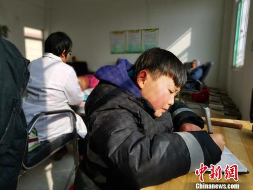 在社區(qū)服務(wù)中心，劉奉智母親為村里人按摩，劉奉智在一旁寫作業(yè)?！『聦W(xué)娟 攝