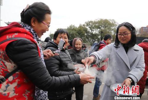 圖為民眾品嘗剛出鍋的湯圓?！『←?攝