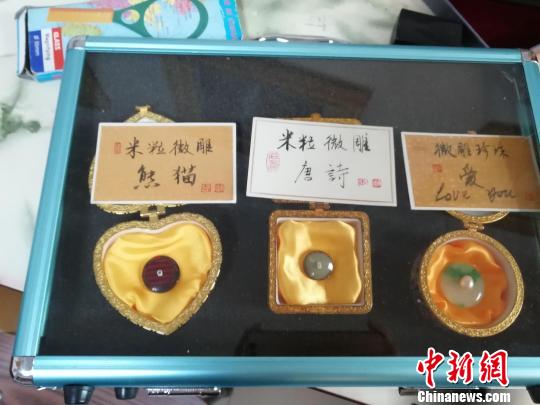 濟(jì)南微雕非遺傳承人王天明將大熊貓、唐詩等微雕在米粒上?！O婷婷 攝