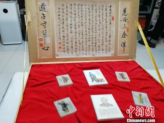 為紀(jì)念母親張春秋，王天明做了一副微雕作品，在五塊郵票樣式的玉石上雕畫了張春秋塑造的經(jīng)典舞臺形象，并刻上了她的京劇唱詞?！O婷婷 攝