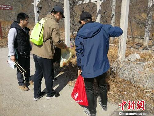 登山隊員們一手握夾子、一手拎袋子，開展登山撿拾垃圾活動。招嘉虹/攝 招嘉虹 攝
