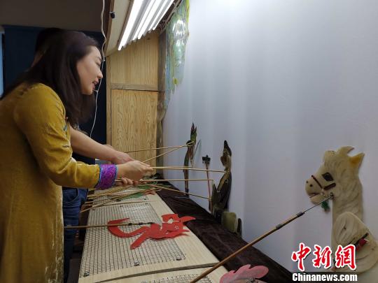 李娟藏在幕布后，繪聲繪色地為觀眾表演《西游記之孫悟空大戰(zhàn)蝎子精》?！≮w曉 攝