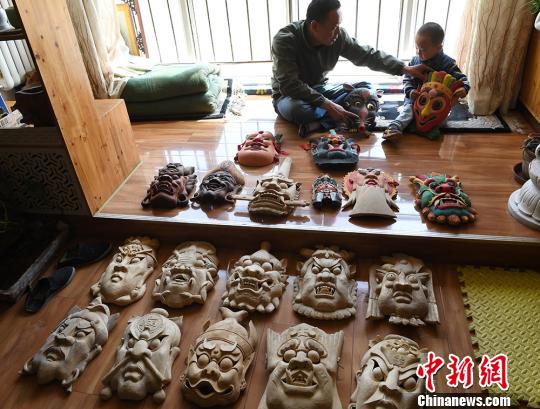 甘肅民間藝人馬正德展示制作的儺面具。　楊艷敏 攝