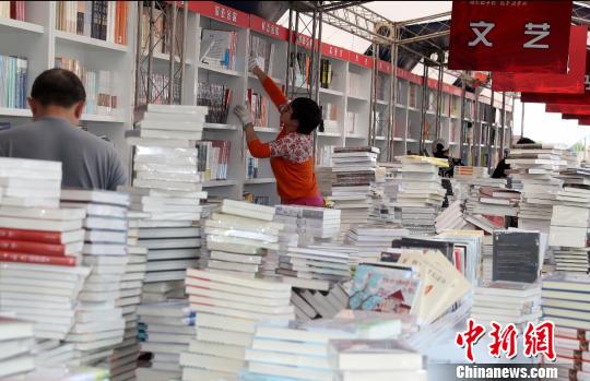 “北京書市”將于4月19日至29日在朝陽公園舉辦。圖為工作人員正在布置展區(qū)內各個書架。(完) 張宇 攝