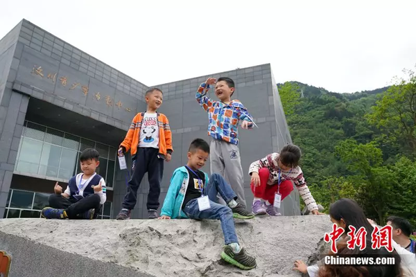 2018年4月22日，孩子們在汶川縣青少年活動中心前玩耍。中新社記者 毛建軍攝