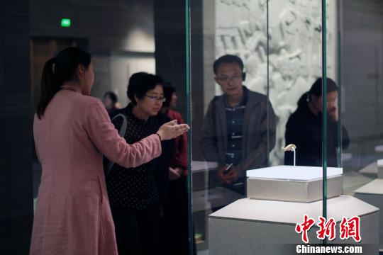 圖為，觀眾在孔子博物館展品前駐足觀賞，仔細聆聽講解員解說。　王飛 攝