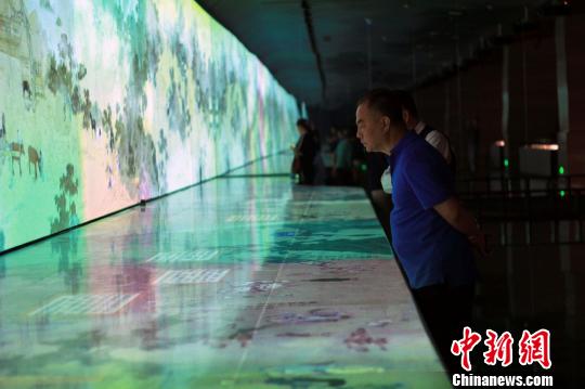 圖為，觀眾在孔子博物館展品前駐足觀賞，了解每件文物背后的故事?！⊥躏w 攝
