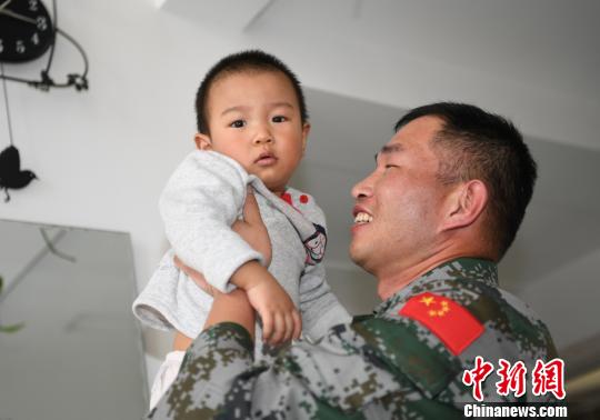 卞龍抱起兒子?！钤傩?攝