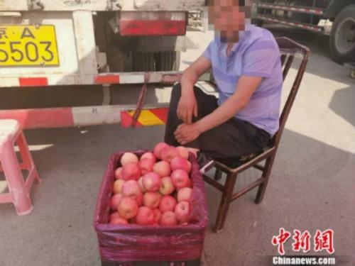 圖為新發(fā)地賣蘋果的攤販。 謝藝觀 攝 