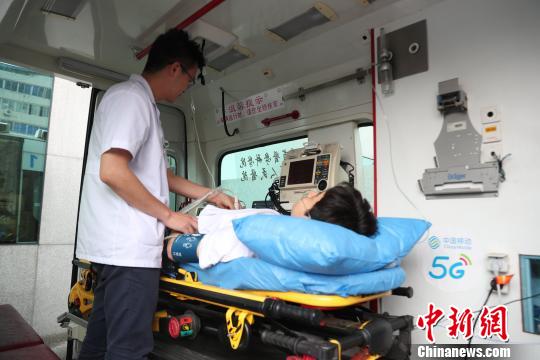 圖為醫(yī)生在5G急救車上檢查病患?！＄娦?攝