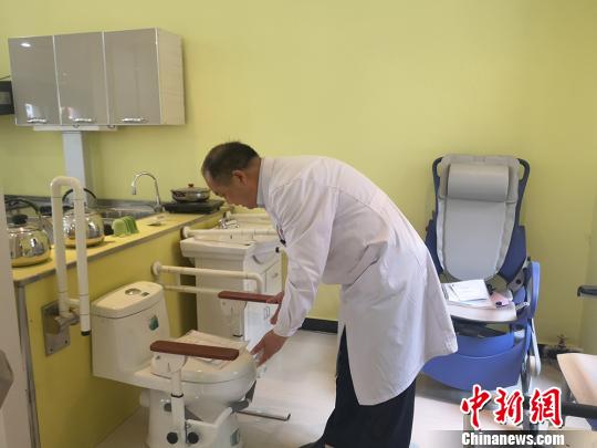 圖為甘肅省輔具中心主任王應(yīng)良進(jìn)行殘障人輔助工具用途的講解?！「呖档?攝