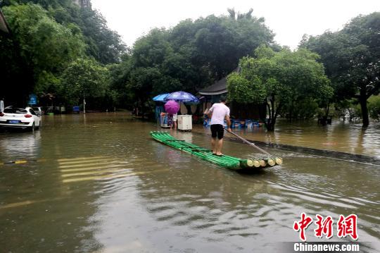 圖為桂林穿山公園部分被淹，附近民眾用竹箋出行?！√茐魬?攝