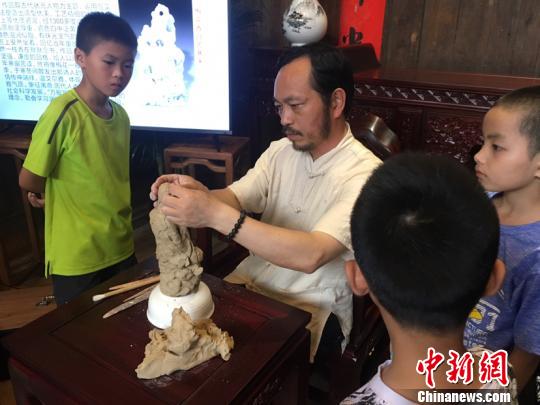 陳明良帶領(lǐng)小游客塑型。吳慧攝