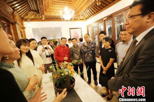 圖為當(dāng)晚在中國(guó)駐東盟大使官邸舉辦的“中國(guó)民俗文化之夜”，各國(guó)外交官賞花藝?！×钟纻?攝