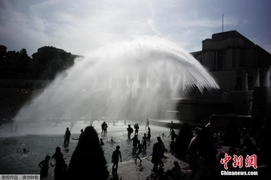 當(dāng)?shù)貢r間2019年6月28日，法國巴黎，法國遭遇連日極端高溫天氣襲擊，眾多巴黎市民和游客聚集在埃菲爾鐵塔前的噴水池泡水降溫。