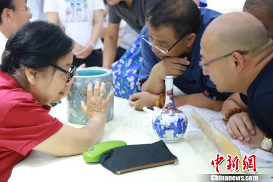 北京市文物鑒定委員會(huì)秘書長張如蘭為市民鑒定收藏品。供圖