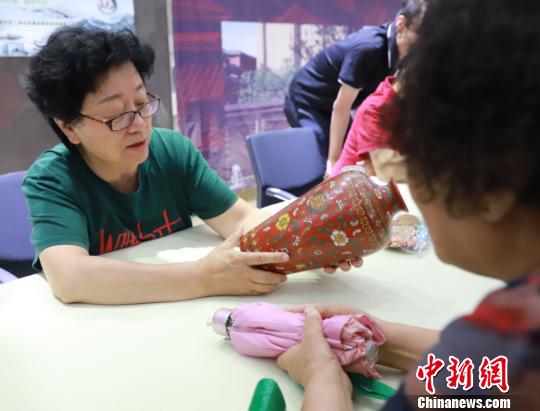 文物鑒定專家現(xiàn)場(chǎng)為市民免費(fèi)鑒定收藏品真?zhèn)巍９﹫D